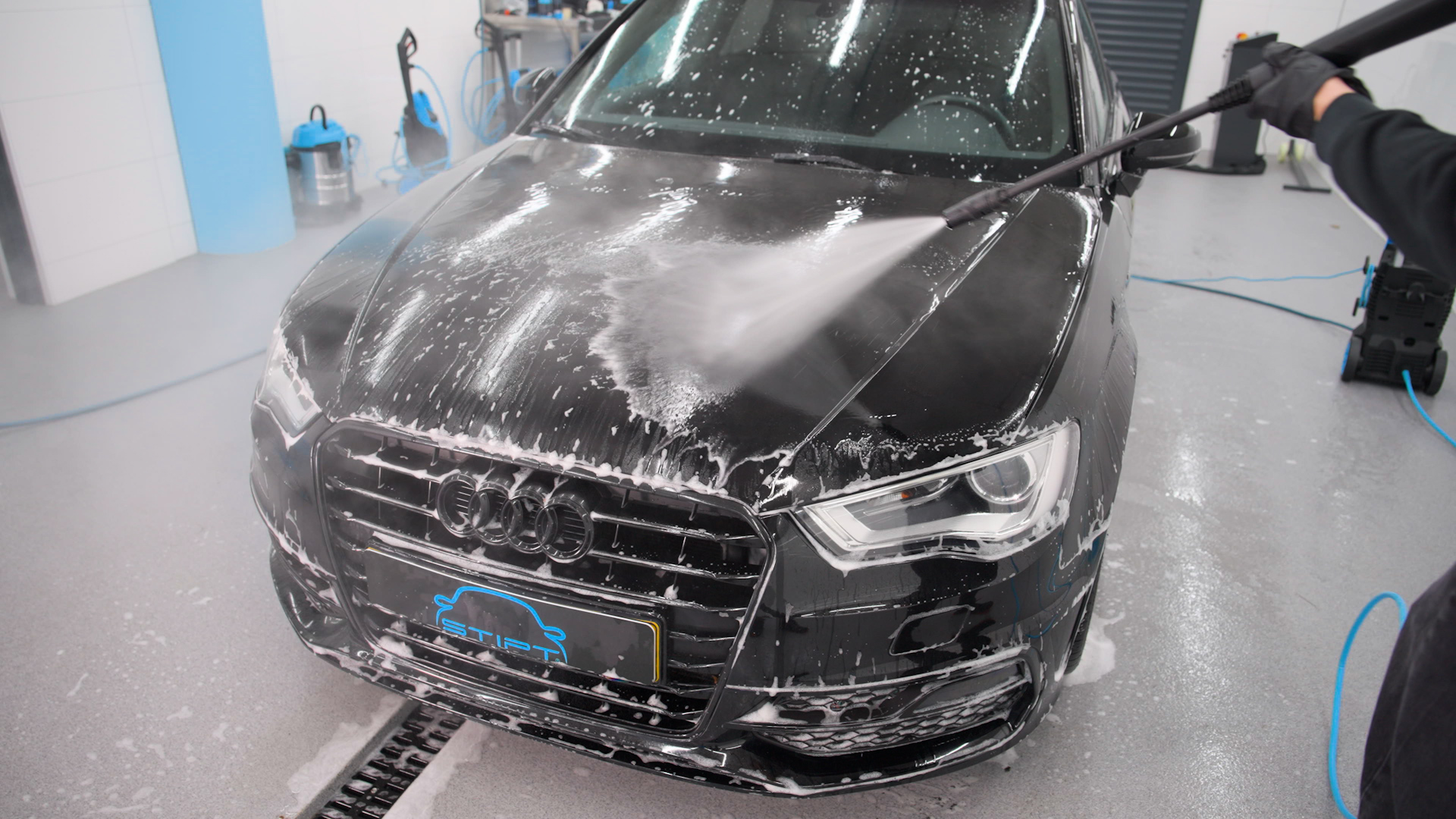 Auto afspuiten met hogedrukreiniger om vuil en shampoo te verwijderen